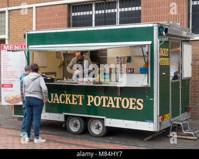 Un couple qui achète des aliments provenant d'un étal de pommes de terre en jaquette Gilkes Street Middlesbrough sur une longue journée de shopping Banque D'Images