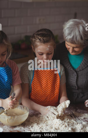 Grand-mère et petites-filles de la préparation en cuisine cupcake Banque D'Images