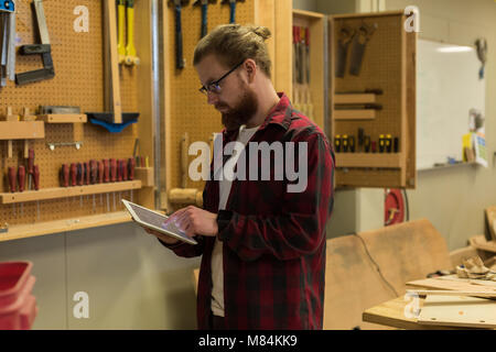 Male carpenter using digital tablet Banque D'Images