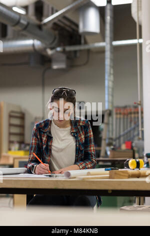 Femme menuisier travaillant en atelier Banque D'Images