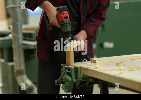 Male carpenter en utilisant drill machine en atelier Banque D'Images