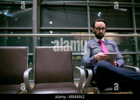 Businessman using digital tablet in waiting area Banque D'Images