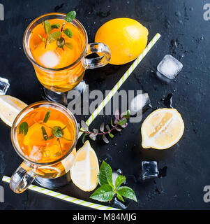 Verres de thé glacé avec les tranches de citron sur fond noir thé glacé rafraîchissant Banque D'Images