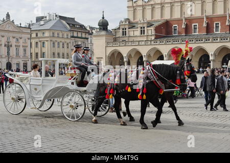 Cracovie, Pologne - 11 mars 2018 : Place du marché, Halle aux draps. Dans l'avant est un revêtement décoratif à chevaux pour transporter les touristes. Banque D'Images