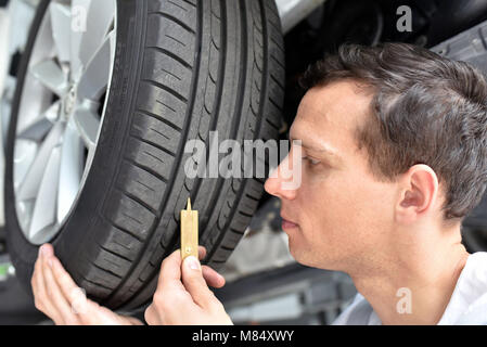 Contrôle mécanique de profondeur des sculptures d'un pneu de voiture Banque D'Images