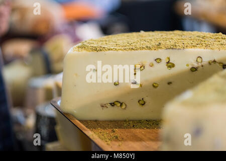 Roue de fromage délicieux avec les pistaches sur plateau en bois en épicerie fine Banque D'Images