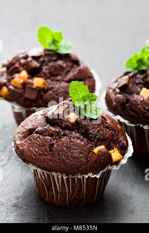 Triple chocolat muffins sur fond noir en noir Banque D'Images