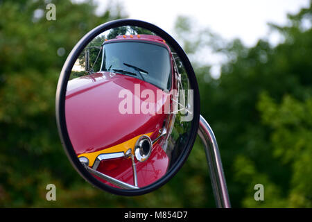Les objets dans le miroir peut être plus proche qu'ils ne le semblent. Réflexion d'un camion rouge corne dans un rétroviseur rond. Banque D'Images