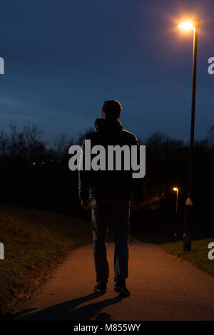 Vue arrière d'un homme marchant dans la distance. Tourné sur toute la longueur. Banque D'Images