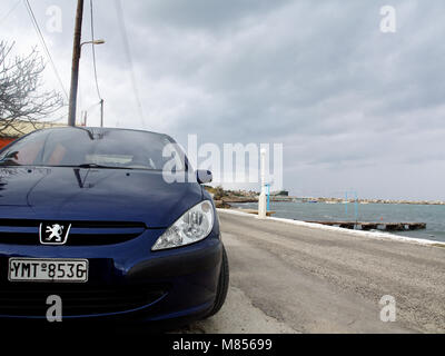 Peugeot 307 bleue garée près de mer à Roda, Corfu, Grèce sur journée d'hiver orageux Banque D'Images