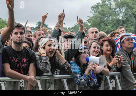 Des foules de gens avec les mains en l'air au V Festival dans le Staffordshire, au Royaume-Uni en attente dans la première rangée pour voir les spectacles sur scène Banque D'Images