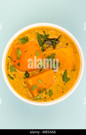 À l'Indienne Curry de courge musquée contre un fond bleu avec copie Espace Banque D'Images