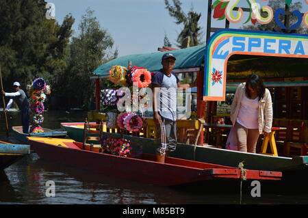 Un homme qui vend des souvenirs sur une trajinera à Xochimilco, Mexico City Banque D'Images