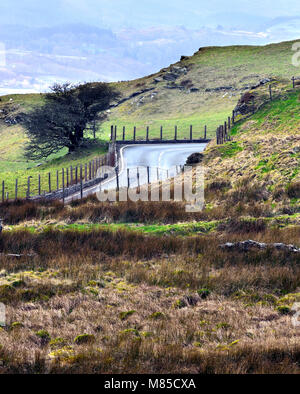 Une route sinueuse traverse le paysage vallonné de Snowdonia, dans les régions rurales du pays de Galles, Royaume-Uni. Banque D'Images