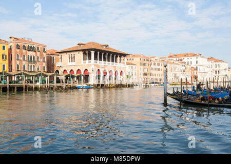 Déserté le Grand Canal et le marché aux poissons du Rialto au lever du soleil, Venise, Vénétie, Italie avec gondoles amarrées au premier plan et deux gondoliers découvrir e Banque D'Images