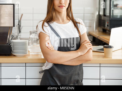 Propriétaire de l'entreprise café Concept - young Beautiful woman barista en tablier avec confiance à la caméra dans un café au comptoir. Banque D'Images