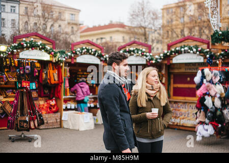 Prague, le 15 décembre 2016 couple européen : l'homme et la femme dans le marché de Noël verre vin chaud et regarder des spectacles de Noël. La célébration de C Banque D'Images