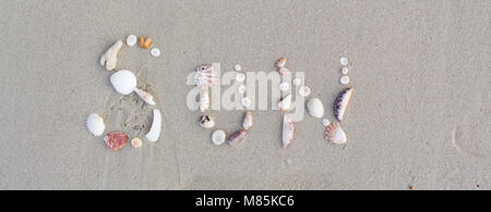 Le mot soleil, écrit avec des coquillages dans le sable sur une belle plage en Thaïlande à Koh Samui Banque D'Images