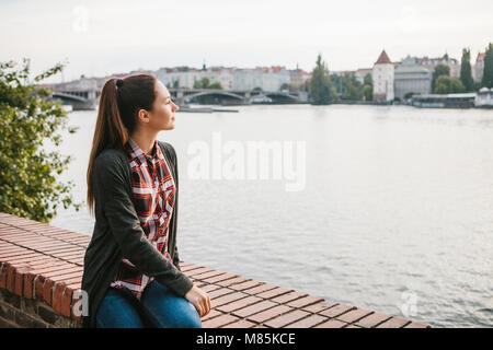 Une belle jeune fille sur les rives de la Vltava à Prague en République tchèque, admire la vue magnifique sur la rivière et l'architecture Banque D'Images