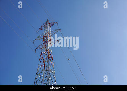 Lignes à haute tension se croisent à un grand poteau métallique dans le Maine contre un ciel bleu. Banque D'Images