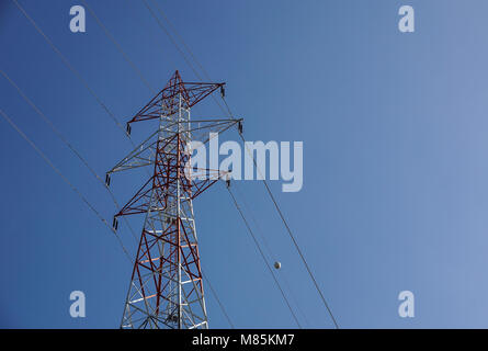 Lignes à haute tension se croisent à un grand poteau métallique dans le Maine contre un ciel bleu. Banque D'Images