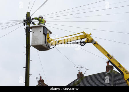 Un BT Openreach ingénieur travaillant sur les câbles téléphoniques à partir d'une grue Banque D'Images