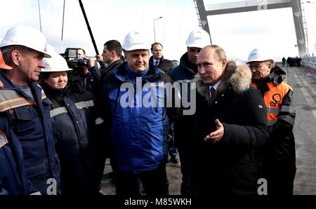 Le président russe Vladimir Poutine parle avec des travailleurs lors d'une tournée de la route-rail pont reliant la Crimée à la Russie continentale le 14 mars 2018 près de Kertch, en Crimée. Le pont fait partie de la stratégie d'achèvement de l'annexion de la Crimée Banque D'Images