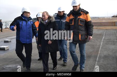 Le président russe Vladimir Poutine parle avec des travailleurs lors d'une tournée de la route-rail pont reliant la Crimée à la Russie continentale le 14 mars 2018 près de Kertch, en Crimée. Le pont fait partie de la stratégie d'achèvement de l'annexion de la Crimée Banque D'Images