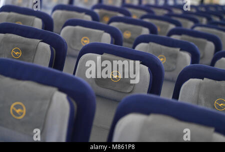 14 mars 2018, l'Allemagne, Frankfurt am Main : Lufthansa logos sur les appuie-tête des sièges en classe économique à l'intérieur d'un Boeing 747-800. Photo : Arne Dedert/dpa Banque D'Images