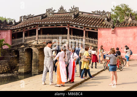 Chùa Cầu visiteurs à côté du pont japonais, un pont en bois sculpté 18e siècle qui comprend une salle de culte, à Hoi An, Vietnam Banque D'Images