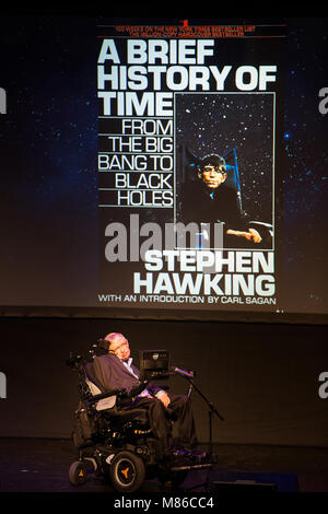 Le professeur Stephen Hawking, scientifique britannique, physicien de renommée mondiale et portrait Une brève histoire du temps, sa couverture de livre sur l'écran de projection, Banque D'Images