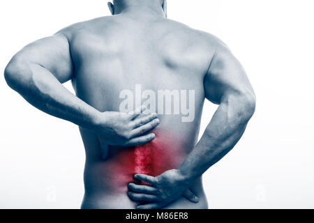 Lésion de la colonne vertébrale. Jeune homme chauve sports physique est titulaire d'un malade sur un arrière-plan blanc isolé. Fracture de la colonne vertébrale Banque D'Images