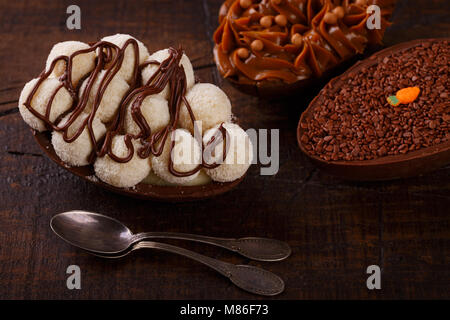 Oeuf en chocolat avec remplissage pour Pâques sur fond de bois. Selective focus Banque D'Images