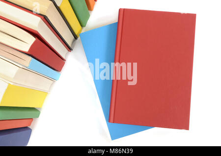 Livre rouge clair avec rangée de livres colorés sur un fond blanc. L'espace pour copier. Banque D'Images