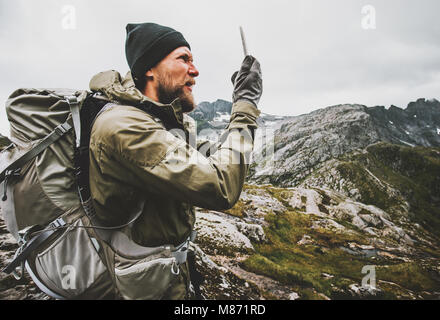 L'homme à l'aide GPS Navigator smartphone voyageur contrôle les coordonnées d'emplacement de la randonnée dans les montagnes avec sac à dos de survie de voyage concept vie outdo Banque D'Images
