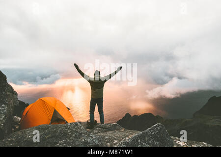 L'homme heureux voyageur mains soulevées en montagne près de la tente camping outdoor Travel adventure concept réussite vie randonnées vacances actives enjoyi Banque D'Images