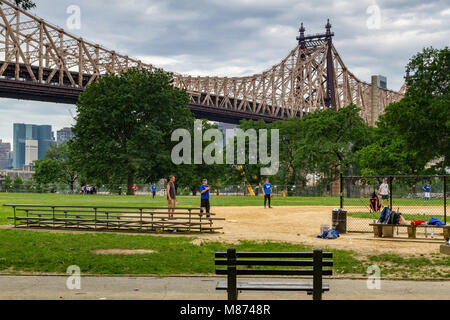 Les gens jouant au baseball à Queensbridge Park, un parc de la ville en dessous du 59th St Queensboro Bridge, long Island City, Queens, New York, Etats-Unis Banque D'Images