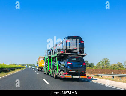 Grande voiture avec remorque porte-voitures sur la plate-forme superposés. Transport de voiture camion sur l'autoroute. Un espace réservé au texte Banque D'Images