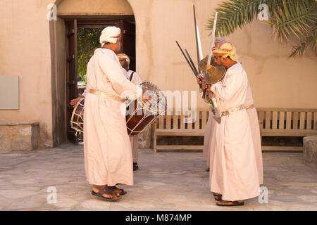 Nizwa, Oman - Omani men danse une danse de l'épée traditionnelle à Nizwa Fort Banque D'Images