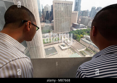 Les personnes à la recherche à la ville d'en haut à partir de la plate-forme d'observation du 27e dans le nouvel hôtel de ville. Toronto, Ontario, Canada. Banque D'Images