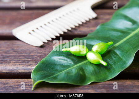 Cheveux vitamine sérum huile capsule sur vert feuille nature arrière-plan. Banque D'Images