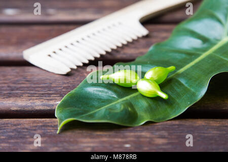 Cheveux vitamine sérum huile capsule sur vert feuille nature arrière-plan. Banque D'Images