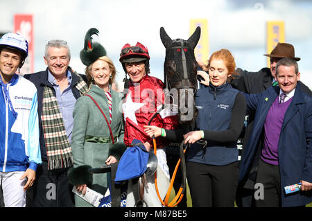 Propriétaire Michael O'Leary (deuxième à gauche), Jockey Davy Russell (centre) et connexions de travail Delta gagnante après avoir remporté le Pertemps Final Réseau lors de St Patrick's jeudi de la Cheltenham Festival 2018 à l'Hippodrome de Cheltenham. Banque D'Images