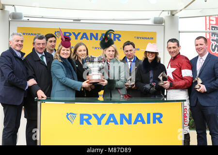 Propriétaire Michael O'Leary (à gauche) et Jockey Davy Russell (deuxième à droite) recueillir le trophée après avoir remporté le Ryanair Steeple Chase à Balko Des Flos au cours de St Patrick's jeudi de la Cheltenham Festival 2018 à l'Hippodrome de Cheltenham. Banque D'Images