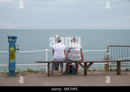 Un couple face à la mer à Southwold, Suffolk, Angleterre. Banque D'Images