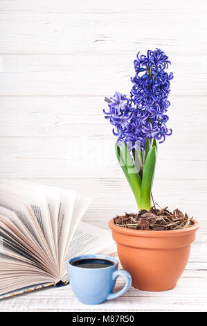 Livre, tasse à café, fleur sur fond de bois. Livre de lecture et de boire du café, de copier l'espace. 8 mars, la fête des mères, vacances concept Banque D'Images