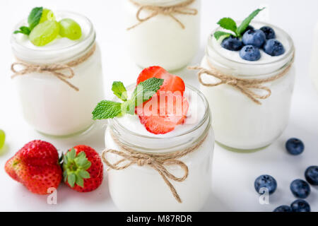 Yaourt frais aux fruits rouges dans des bocaux en verre. Les produits laitiers. L'alimentation saine, les régimes et l'idée de petit-déjeuner Banque D'Images