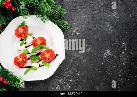 Salade Caprese en forme d'arbre de Noël. Apéritif festif sur le tableau noir. Réglage de la table de Noël avec de la salade caprese concept. Noël backgroun Banque D'Images