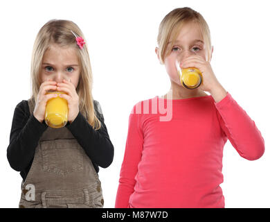 Enfants filles enfants de boire du jus d'orange une saine alimentation format portrait isolé sur fond blanc Banque D'Images