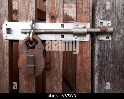 Fermoir cadenas rouillés et agrafe fixation de porte en bois à côté du bâtiment résidentiel Banque D'Images